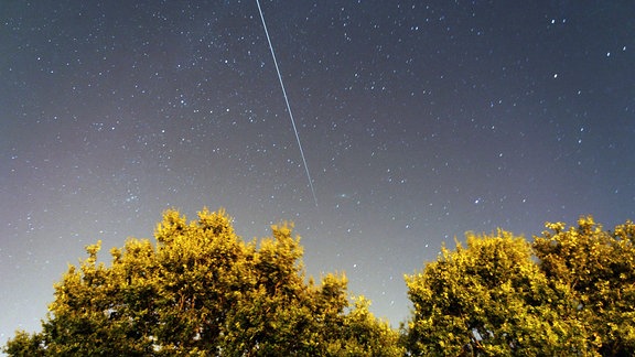 Die Internationale Raumstation (ISS) hinterlässt in dieser 61-Sekunden-Belichtung eine Spur während sie den Nachthimmel durchfliegt.