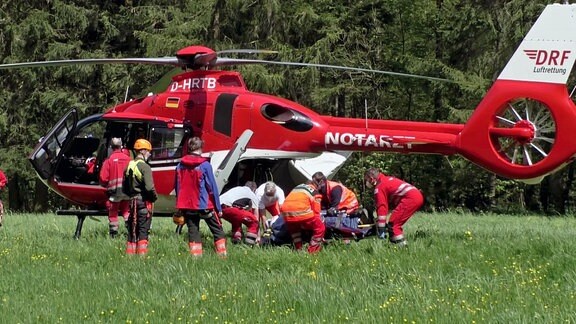 Eine Gruppe der Bergwacht verlädt einen Verletzten in einen Notarzthubschrauber.