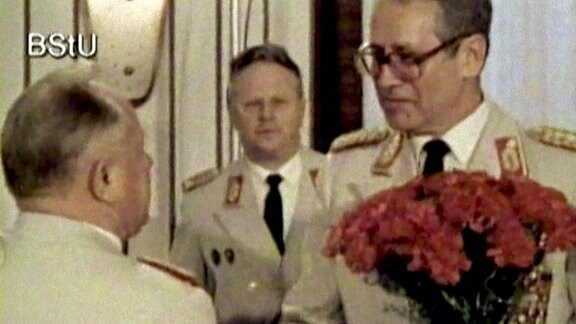 Stasi-Chef Erich Mielke überreicht DDR-Oberspion Markus Wolf Blumen.