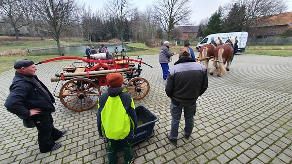Die insgesamt 10 Kameraden der Freiwilligen Feuerwehr in Eilsdorf testen ihre „Pferdegezogene Handspritzpumpe“. Vor 100 Jahren wurde damit im Dorf gelöscht.