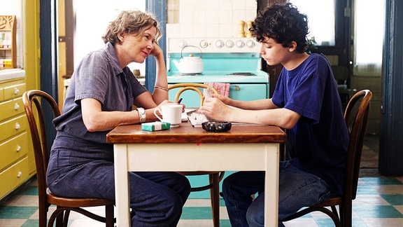 Dorothea (Annette Bening) sitzt ihrem Sohn Jamie (Lucas Jade Zumann) an einem Tisch gegenüber.