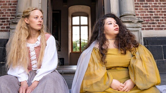 Helene (Caroline Hellwig) und Fee Cleo (Barbara Colceriu) sitzen vor dem eben erst erschaffenen Schloss, als ein Unbekannter an das Tor klopft.