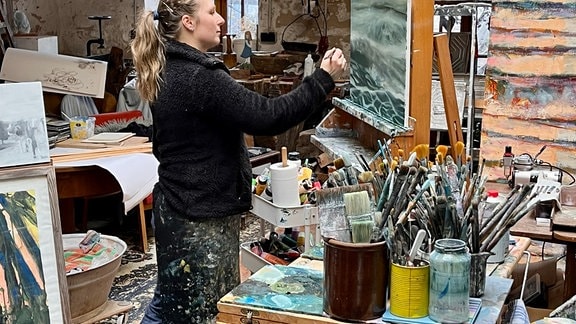 Eine Malerin vor einer Leinwand