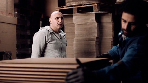 Murat (Erol Afsin, re.) erzählt Tobi (Volkan Türeli), dass die Kartonfabrik schon nächsten Monat geschlossen wird.