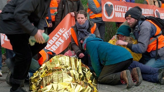 Ein verletzter Aktivist liegt auf dem Boden nach der Räumung der Blockade in Berlin.