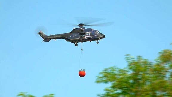 Ein Hubschrauber der Bundespolizei bei Löscharbeiten eines Waldbrands.