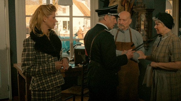Der Obersturmbannführer (Ralph Herforth, li.) und Frau Müller (Silvia Elfert) im Laden des Koffermachers (Rüdiger Smorra, re.) und Oma Hilde (Brigitte Vaas).