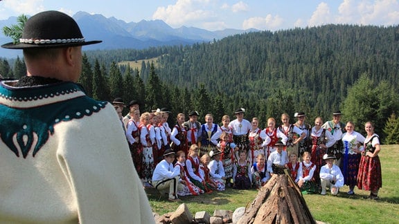 Ein goralischer Chor singt in traditionellen Trachten.