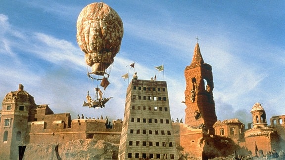 Um die Bewohner der von den Türken belagerten Stadt zu retten, fliegt Münchhausen mit einem Ballon aus Damenunterwäsche zum Mond.