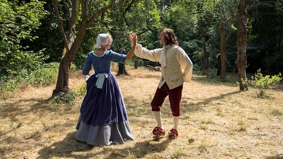 Kammerzofe Lisbeth (Luise von Finckh) lernt Johann (Jonas Lauenstein) die höfischen Tänze.