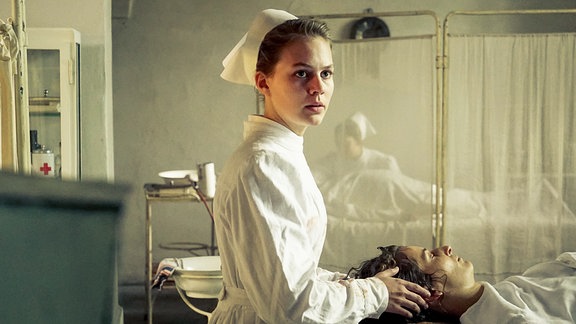 Ida (Alicia von Rittberg, l.) assisitert bei der Operation von Hedda Ehrlich (Stella Hilb, r.).