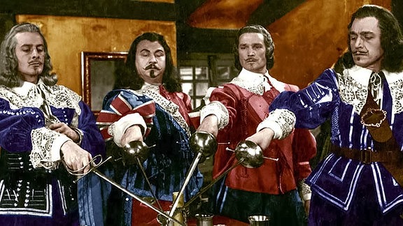 Vier Männer in barocken Kostümen kreuzen ihrre Degen.