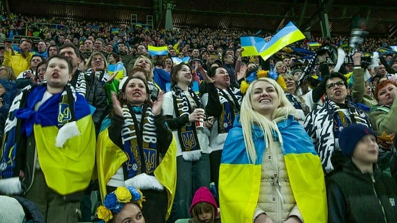 Blick auf Zuschauer eines Stadions mit ukrainischen Fahnen.