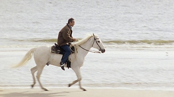 Nils (Hannes Jaenicke) reitet über den Strand.