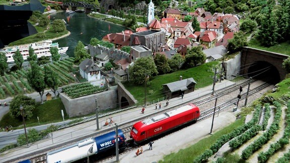 Blick auf eine Modelleisenbahn am Rande einer Miniaturstadt.