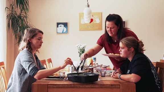 Drei Frauen sitzen am Mittagstisch Wenn Kinder und Jugendliche pflegen