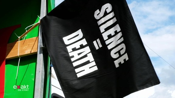 Ein schwarzes Banner auf einer Demo mit der Aufschrift "SILENCE = DEATH".