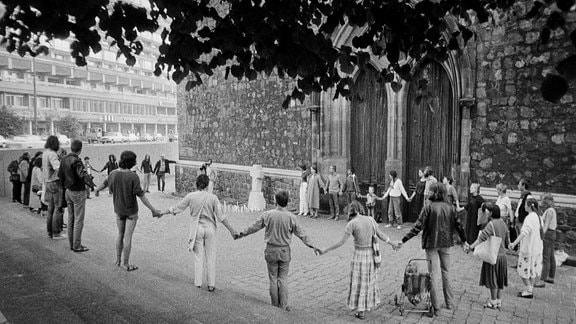 Archivbild: eineMenschenkette vor einer Kirche