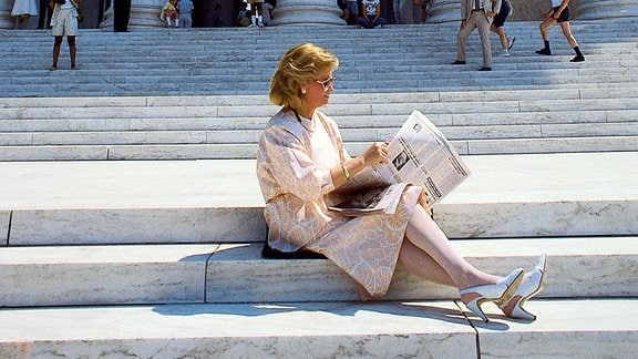 Hannelore Kohl sitzt Zeitung lesend auf der imposanten Treppe des Kapitol in Washington.