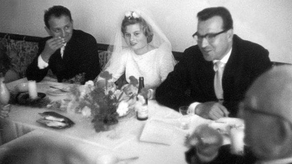 Das Brautpaar Hannelore und Helmut Kohl sitzen an einem Tisch.