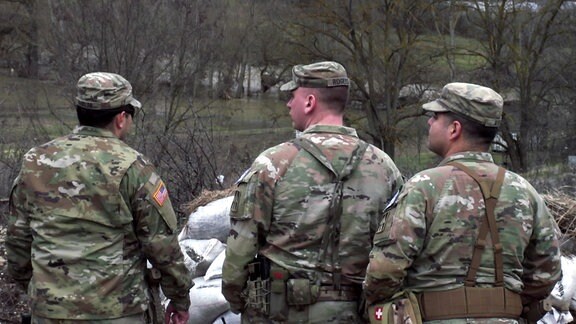 Drei amerikaische Soldaten blicken in die Ferne.