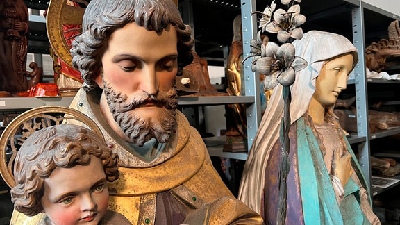 Blick in ein Lagerraum mit bemalten Heiligenfiguren.