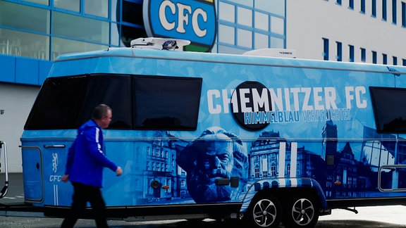 Ein Mann geht an einem Bus des Chemnitzer FC vorbei.