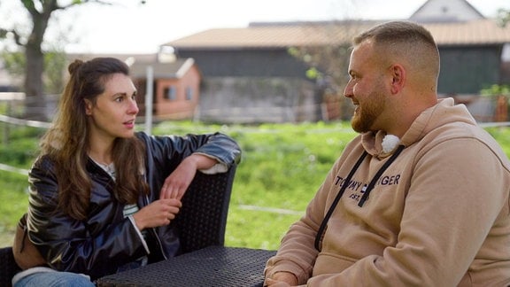 Eine junge Frau und ein junger Mann bei einem Gespräch.