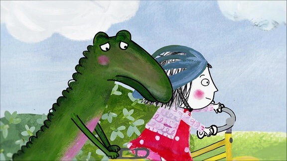 Rita und das Krokodil fahren Fahrrad.