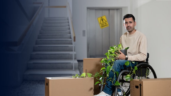 Ein dunkelhaariger Mann sitzt in einem Rollstuhl vor einer Treppe neben einem kaputten Fahrstuhl umgeben von drei Umzugskartons und hält eine Pflanze auf seinem Schoß.