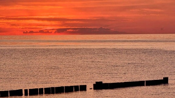 Ostsee, Kühlungsborn. Blick auf die Ostsee, der Himmel ist von der auf- oder untergehenden Sonne rot gefärbt.