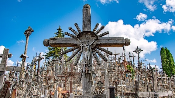 Blick auf ein Meer aus dicht beieinander stehenden christlichen Holzkreuzen unterschiedlicher Gestaltung