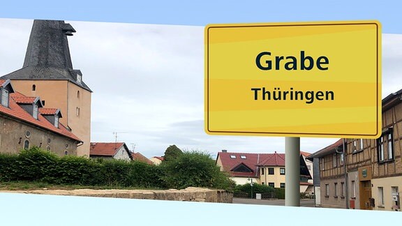 Ausgeschnittene Ortsansicht auf hellblauem Grund mit einem gelben Ortsschild davor, auf dem „Grabe, Thüringen, 03.07.2022 / 9 Uhr“ steht.
