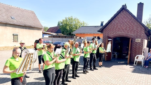 Ein Spielmannnszug musiziert auf einem Hof.