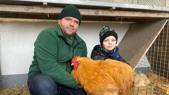 Vater und Sohn mit einem großen Huhn