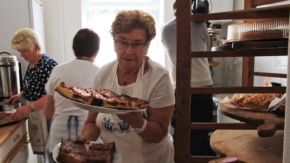 Eine Frau serviert Kuchen