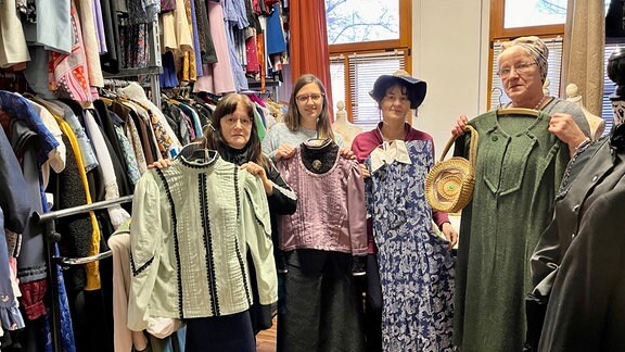 Mehrere Menschen stehen in einem Geschäft mit historischer Kleidung