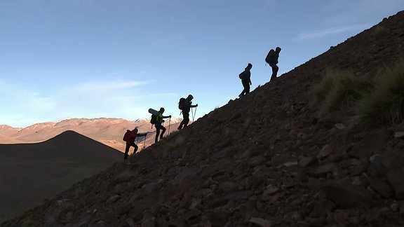 Die Silhouette von fünf Bergsteigern