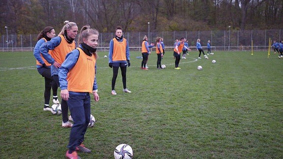 Ein Frauenteam beim Training auf dem Fußballplatz.