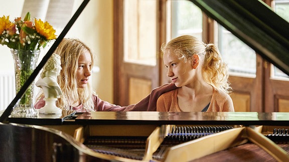 Lotte (Delphine Lohmann) spielt Luise (Mia Lohmann) auf dem Klavier vor