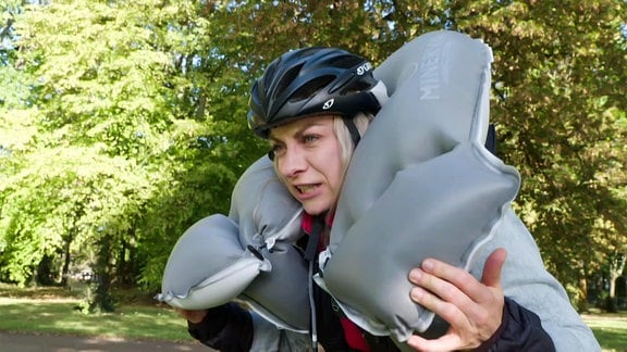 Eine Frau mit Fahrradhelm und einem Airbag um den Hals.