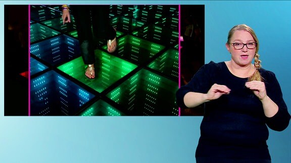 Frau DGS  zeigt auf dem Monitor stromerzeugende Fliesen