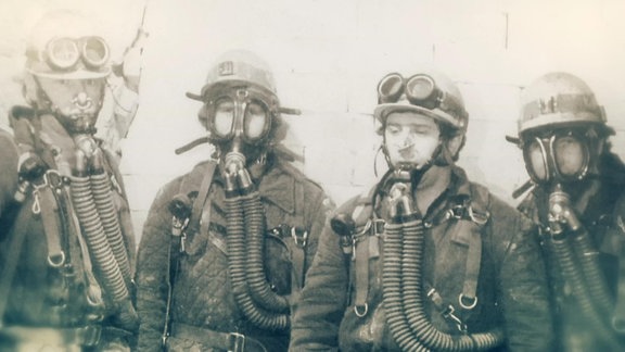 Eine Schwarz-Weiß-Fotografie von Männern in Schutzkleidung