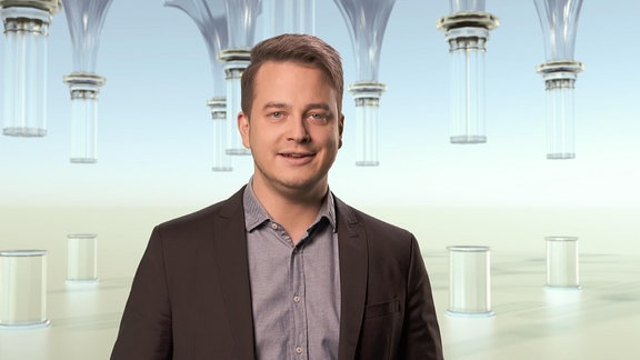 Ein Mann steht in einem Raum mit gläsernen Säulen.