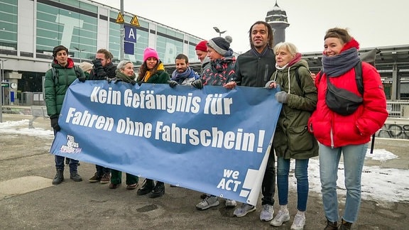 Demonstranten mit Plakat gegen "Gefängnis für Schwarzfahrer"