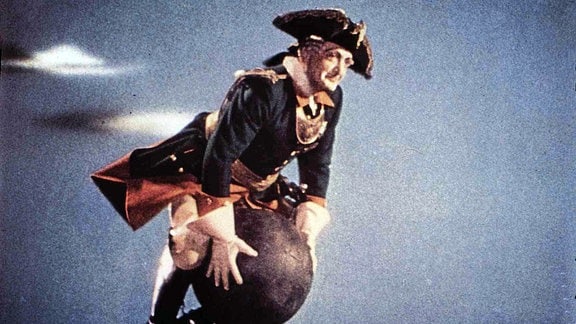 Hans Albers als Baron Münchhausen fliegt auf einer Kanonenkugel.