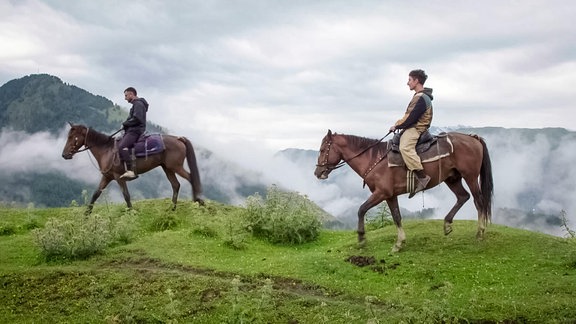 zwei Männer reiten auf Pferden