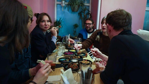 Eine Gruppe von Menschen beim Essen an einem Tisch.