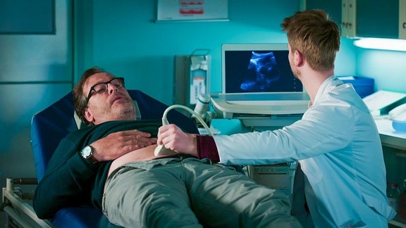 Arzt macht Ultraschall an liegenden Patienten