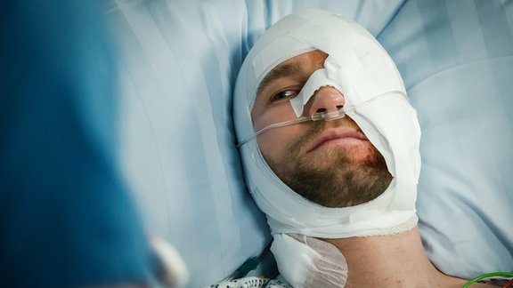 Mann mit verbundener Gesichtsverletzung